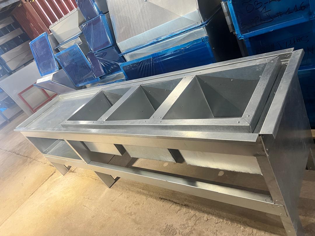 Fabricated galvanized steel drainage channel sections stacked in our workshop