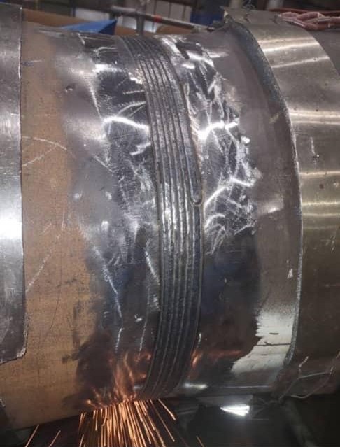 Close view of a welded seam on a curved steel pipe